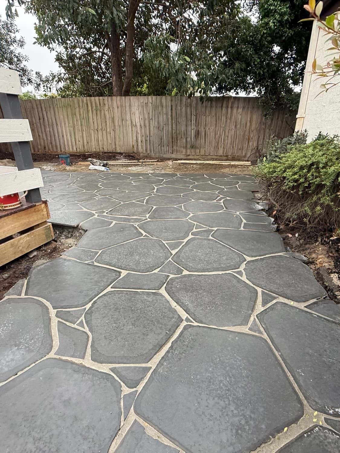 Bluestone crazy paving patio between a timber deck and a garden bed